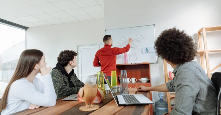 Group of young adults collaborating on design ideas in a modern office setting.